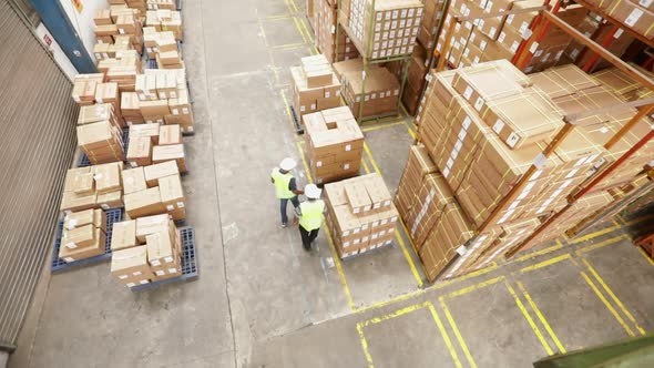 Warehouse Workers Inspect Cardboard Boxes alt