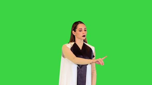 Cyber Girl Stands Operating Virtual Monitors on a Green Screen Chroma Key