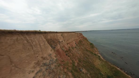 FPV Flight Over a Coastal Cliff at Cloudy Day