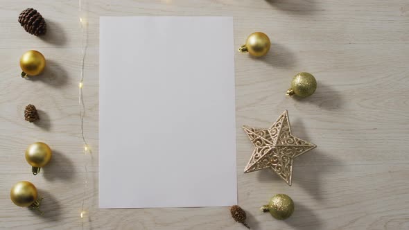 Video of christmas decorations with white card and copy space on wooden background alt