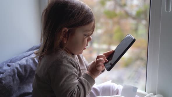 Toddler Child Using Phone at Home, Taking Photos and Playing Games alt
