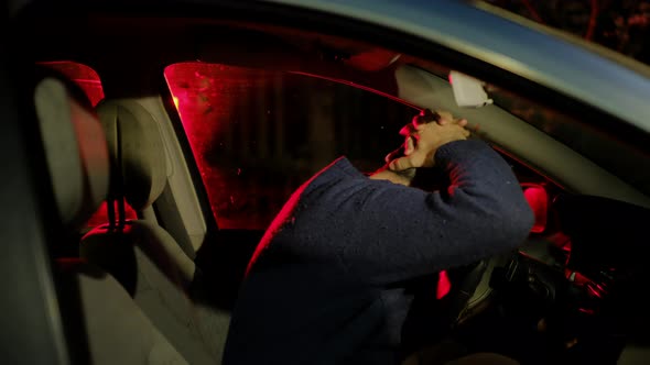 Drunk Driver Inside Car Salon Puts Crossed Hands on Head