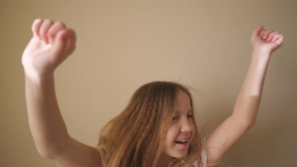 Happy Pretty Blonde Girl Looking Into Camera and Raises Hands Rejoicing Achievement Indoor. Portrait alt