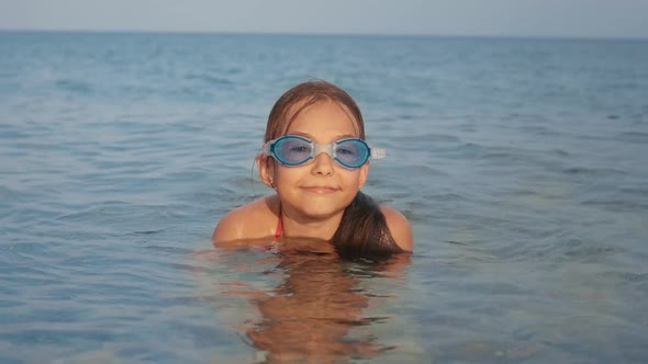 Portrait of Young Girl in Water Mask Relaxing in Sea Water. Child Enjoying Rest alt