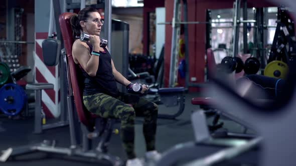 Health Concept. Portrait of Middle-aged Female Doing Physical Exercise with Dumbbells in Gym. 30s or alt