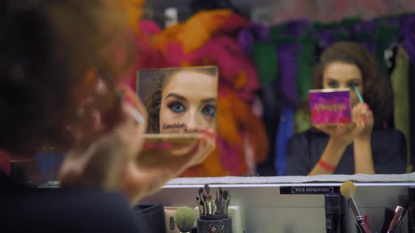 Girl Draws the Outline of the Eyes with a Contoured Eyeliner in Front of the Mirror