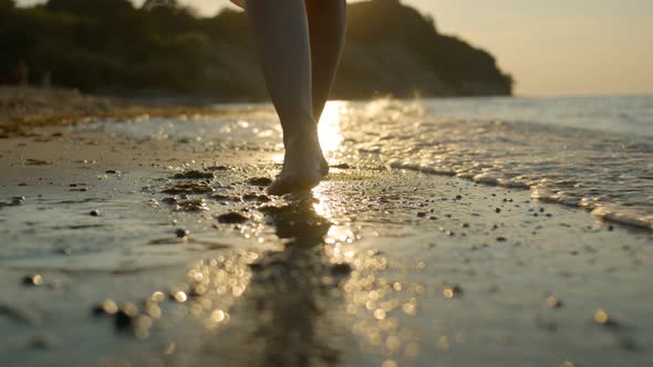 Girl feet walk along the sandy sea beach