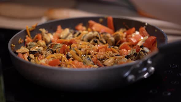 Hands Poured Sauce Into Frying Pan with Seafood and Vegetables