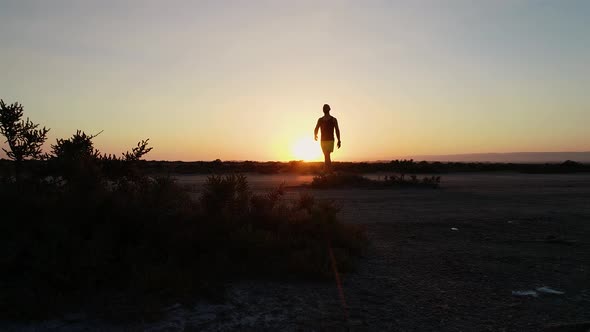 Young Athletic Man Walking Outdoors at Sunset After Workout