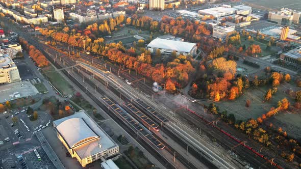 Aerial drone view of Brasov at sunrise, Romania. Railway station, yellowed trees alt