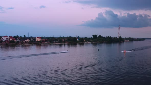 Aerial View of Jetski and Sport Powerboat Crossing Across Buoy at Dusk alt