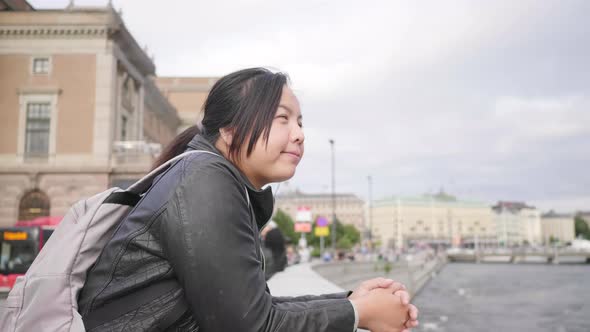 Asian woman standing and seeing beautiful view of river in Sweden alt
