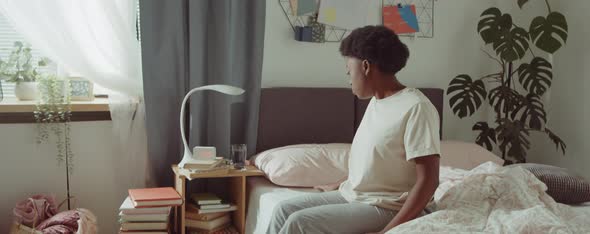 African American Woman Using Phone on Bed in Morning alt