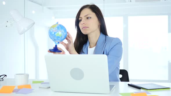 Businesswoman Holding and Reading World Globe alt