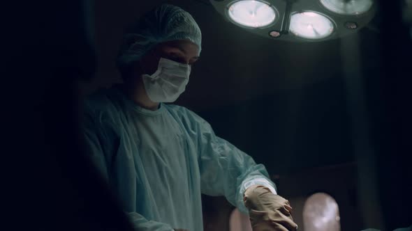 Surgeon Performing Hard Operation Taking Out Bloody Tampon in Emergency Room alt