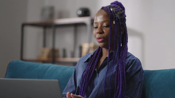 Afroamerican Lady is Conducting Webinar or Online Consultation By Laptop Looking at Display and alt