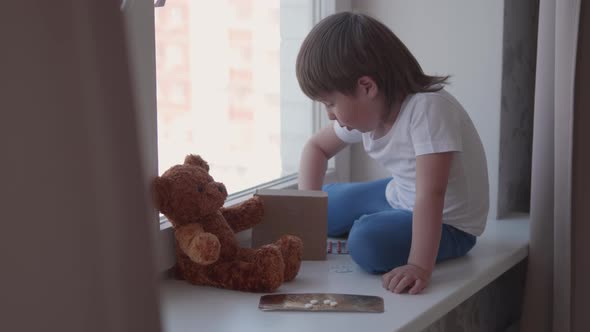 Toddler Sits on Windowsill and Plays with Scattering Pills Without Parent's Control. Dangerous alt