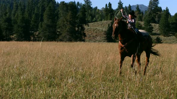 Young boy riding horse with lasso, slow motion alt
