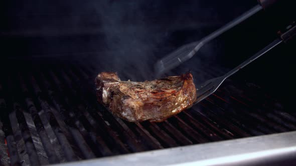 Person Turning Meat on Grill