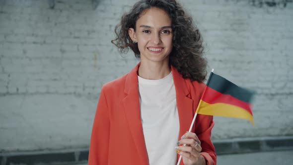Slow Motion Portrait of Attractive Mixed Race Woman Holding German Official Flag Standing Outdoors alt