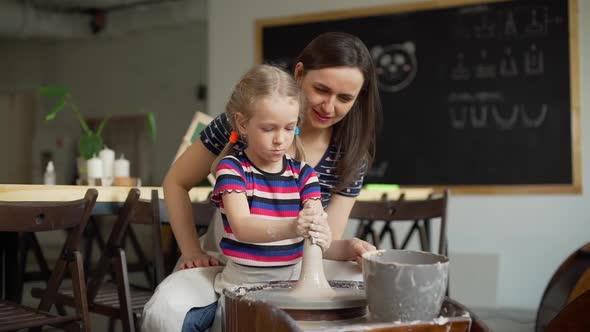 Mother and Daughter in a Pottery Workshop alt
