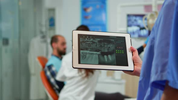 Close Up Dentist Nurse Holding Tablet with Digital Radiography alt