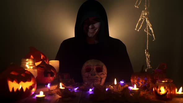The Hooded Man Who Practices Witchcraft Smiles Ominously and Looks at Camera alt