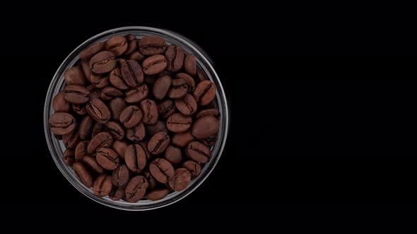 roasted coffee beans on black background, top view rotation. 4K UHD video alt