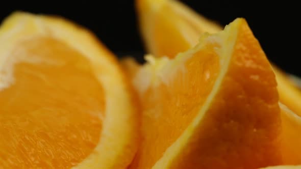 Rotated Sweet Orange Sliced For Dessert In A Glass Plate On A Black Background alt