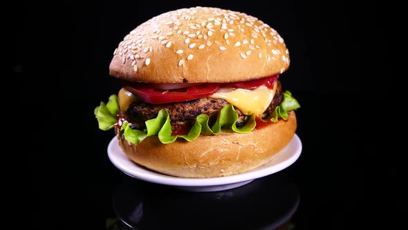 Appetizing burger on a black background. Delicious fast food.