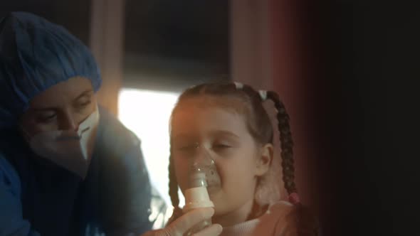 Beautiful Little Girl Makes Inhalation Using a Compressor Inhaler at Hospital alt