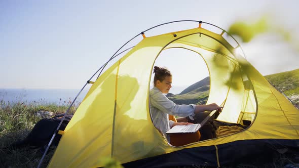 Woman Begin Working on Laptop in Tent at Nature