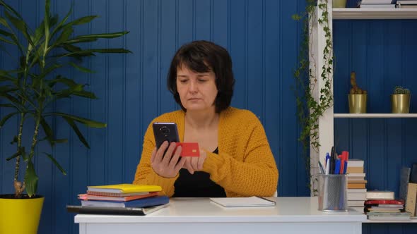 Middle Aged Woman Shopping Online on Mobile Phone with Credit Card