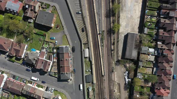 drone shot over railway passing through gentrified suburban london alt
