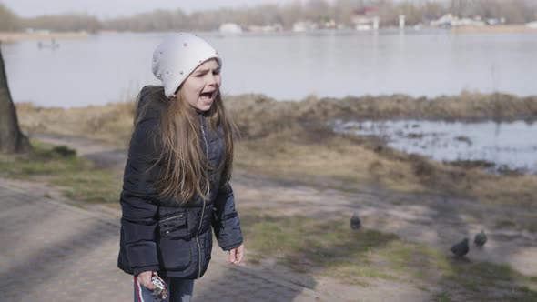 Impatient Caucasian Girl Training Pet in Park. Dissatisfied Little Child Calling for Cute alt
