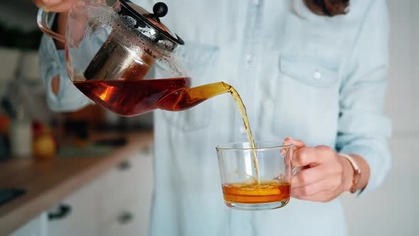 Young woman holding a glass teapot