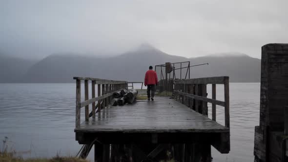 Hiker On Old Pier In Fjord alt