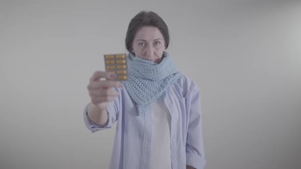 Portrait of Adult Caucasian Woman Holding Blurred Blister Pack of Pills. Brunette Lady Showing alt