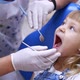Little child in stomatology chair - close up. Cute blonde girl opened her mouth for teeth check up. - VideoHive Item for Sale