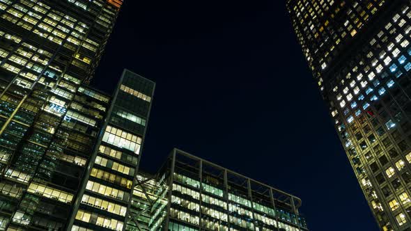 Motion time lapse of sky scrapers in a modern city at night