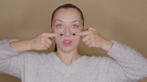 Young Female Blogger Practicing Face Yoga, Showing Skin Massage Lines