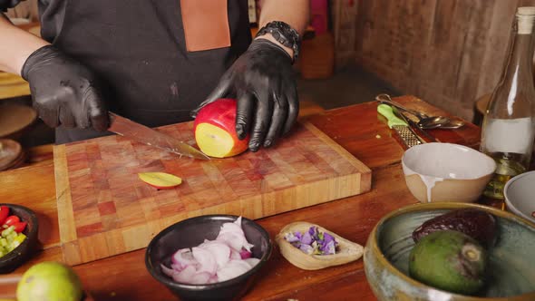 A male professional culinary chef cutting and peeling fresh mango on a chopping board, preparing ing alt