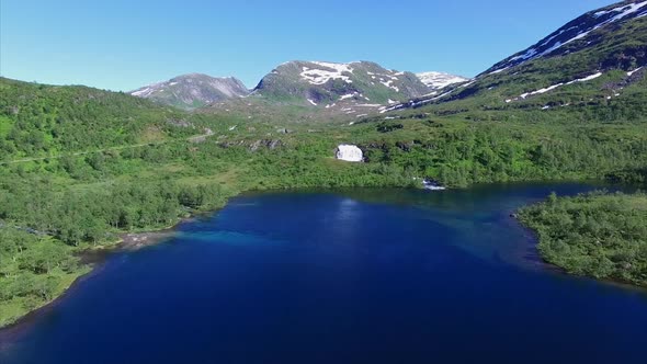 Flying above lake towards waterfall in Norway alt