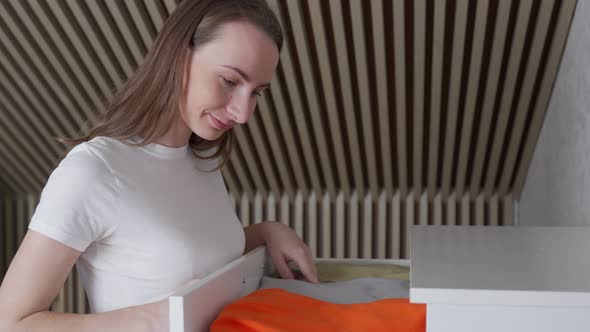 Woman Takes Clothes Out of a Dresser alt