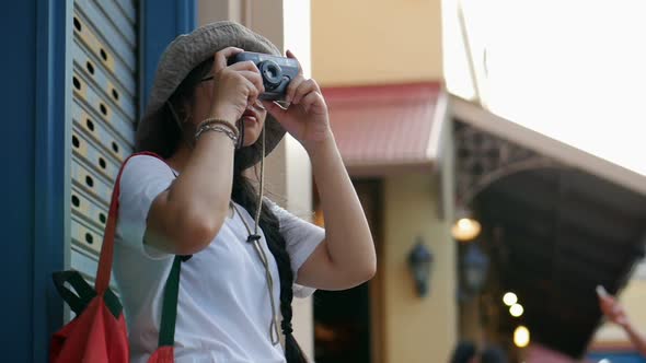 Young Asian woman traveler taking photos around at the market.