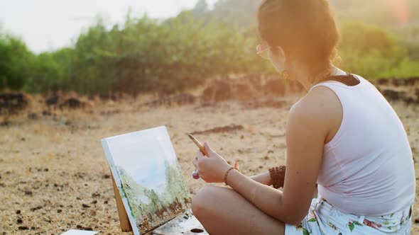 Female Artist Working on Masterpiece Landscape Sitting on Summer Nature Background. Attractive Girl