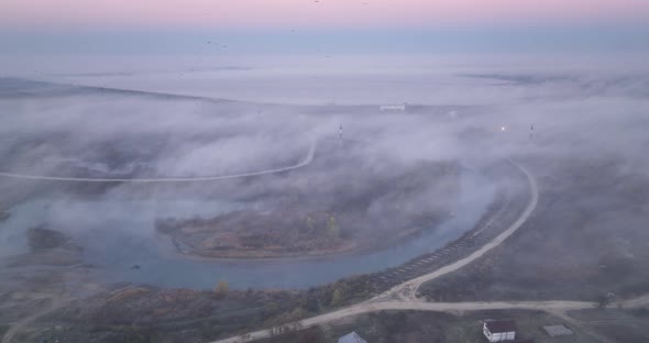 Drone Shot Flying Above Foggy Little Lake During Morning Sunrise in Late Autumn alt