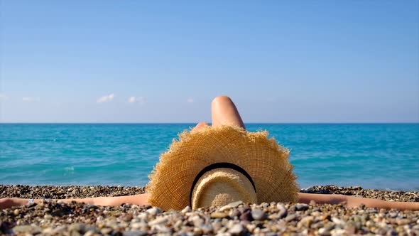 The Girl in the Hat Lies on the Beach alt