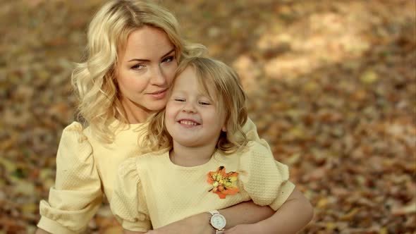 Happy Mother with Her Daughter in Autumn Park alt