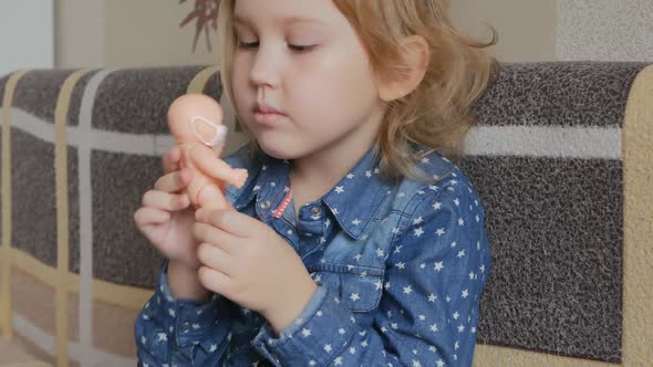 Beautiful and Cute Baby Girl Playing with Bobblehead on the Couch